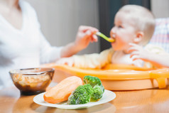 妈妈喂婴儿汤。健康和自然的婴儿食品