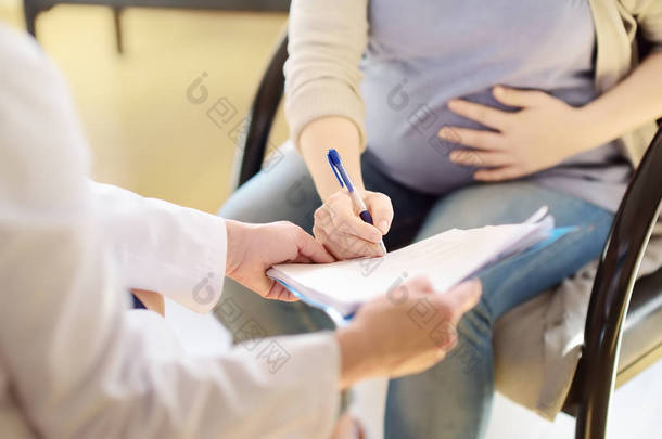 孕妇在接受妇科<strong>医生</strong>期间签署合同或许可证。生育医疗保险。家庭<strong>医生</strong>妊娠。产假.