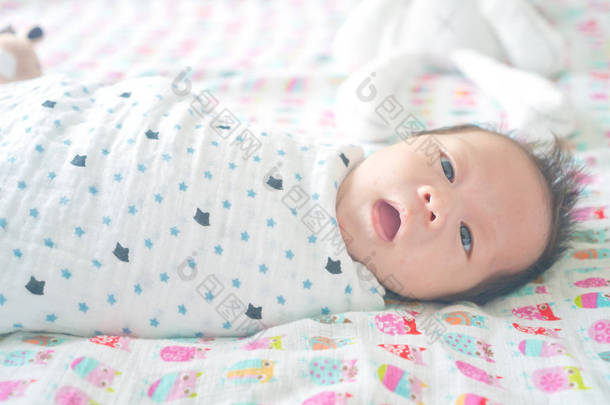 可爱可爱的<strong>婴儿</strong>男孩裹在毯子或<strong>襁褓</strong>, 睡觉, 有时两只眼睛打开在儿童床上
