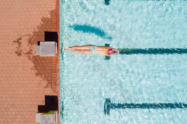 游泳池里一位漂亮的女游泳运动员准备训练的空中图像.