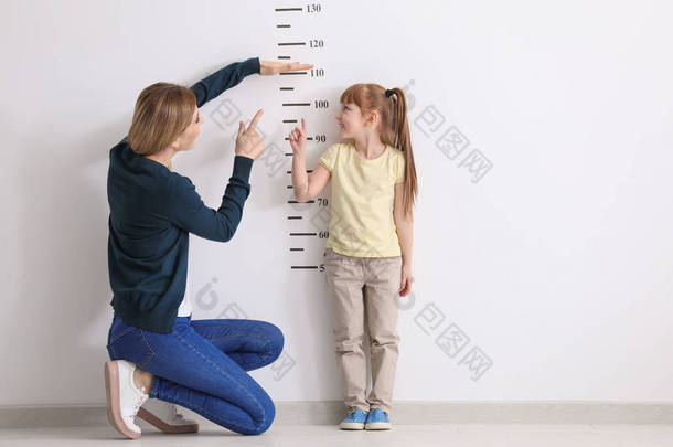 测量身高的女儿的母亲 