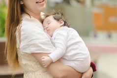 亚洲户外拥抱她的婴儿的母亲
