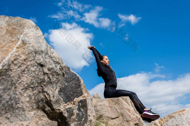 嬉戏的女人坐在石头上