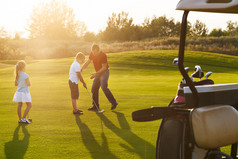 休闲的孩子们抱着高尔夫俱乐部学习与 trai 高尔夫球场