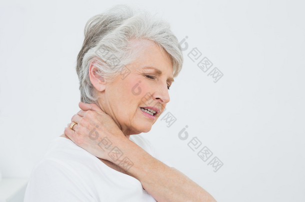 一个高级的女人患有颈部疼痛的侧视图
