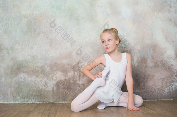 做伸展的白色泳衣课前的小芭蕾舞演员