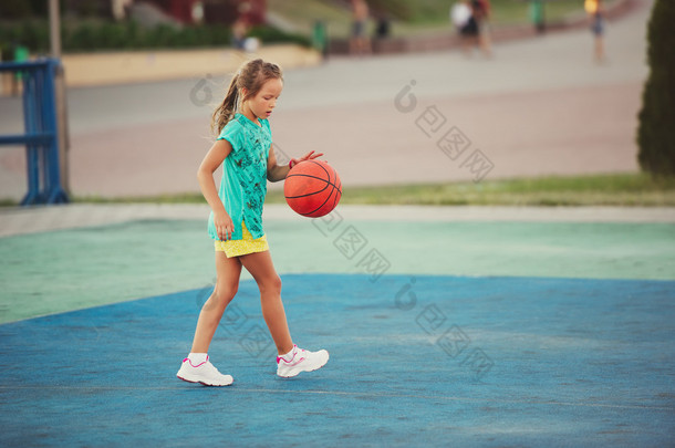可爱的小女孩在户外篮球