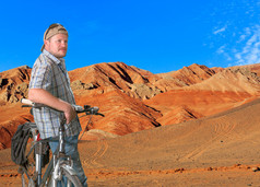 旅游人站立与在高原上的一辆自行车