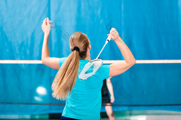 在健身房，妇女打<strong>羽毛球</strong>运动