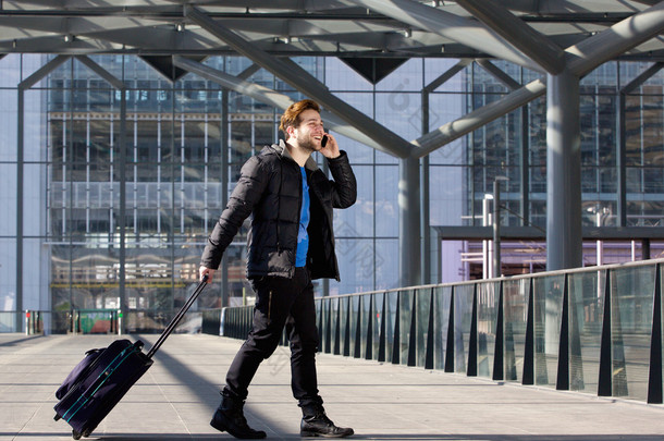 男人走行李箱与移动电话在机场