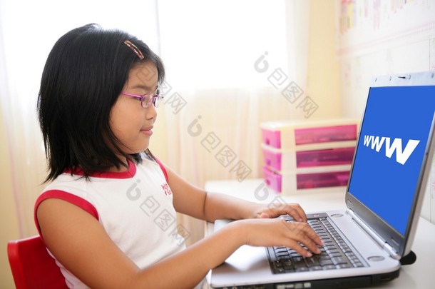 亚洲女孩玩桌上的笔记本电脑