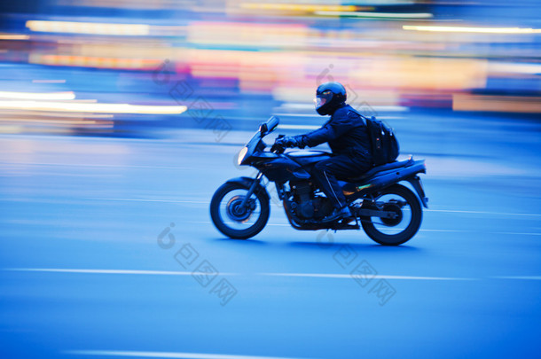 摩托车在夜间交通在运动模糊