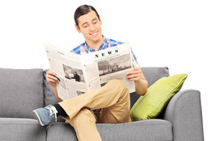 男人坐在沙发上阅读新闻