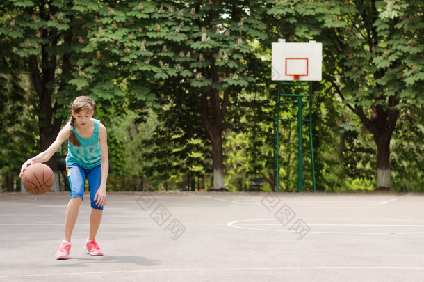 年轻的姑娘运球篮球