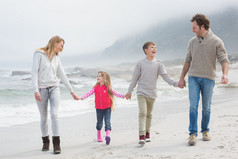 幸福的家庭，四手挽手漫步在海滩上