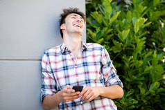 一个手持手机笑的年轻人的画像