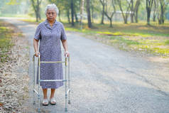 亚洲老年妇女患者与步行者在公园散步：健康有力的医疗理念 