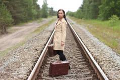 铁轨上有手提箱的女人