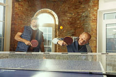 老年人在工作场所打乒乓球，玩得很开心