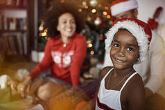 在装饰过的圣诞树前微笑的女孩。一家人庆祝圣诞节