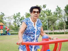 亚洲老年妇女带着户外器械、救生圈做运动