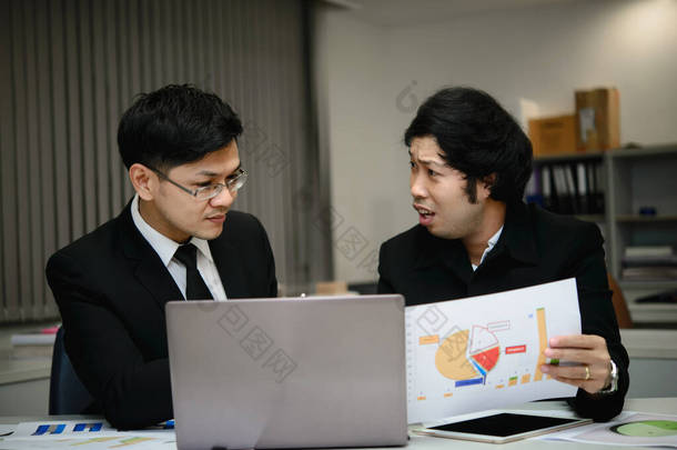 两个亚洲商人在<strong>谈论</strong>公司的业务，两个人在<strong>谈论</strong>工作压力和更严重的问题.