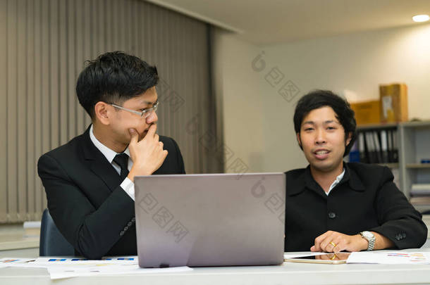 两个亚洲商人在<strong>谈论</strong>公司的业务，两个人在<strong>谈论工作</strong>压力和更严重的问题.