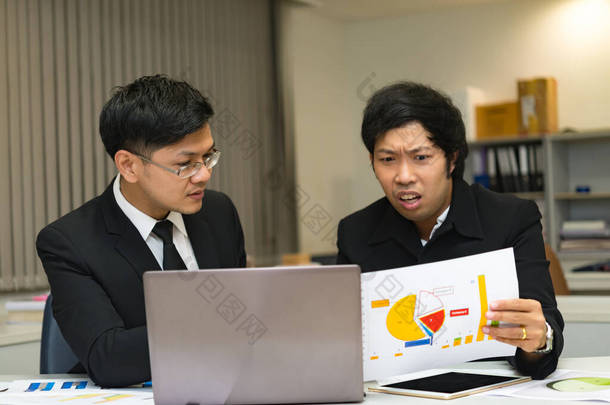 两个亚洲商人在<strong>谈论</strong>公司的业务，两个人在<strong>谈论工作</strong>压力和更严重的问题.