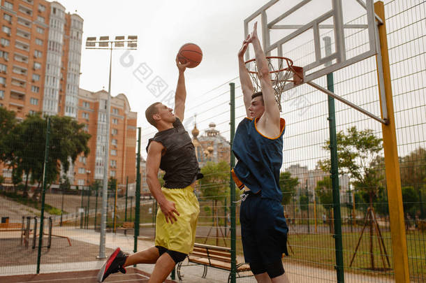 两个<strong>篮球</strong>运动员在室外场地上打球. 男子运动员穿着<strong>运动服</strong>在街头<strong>篮球</strong>训练中比赛