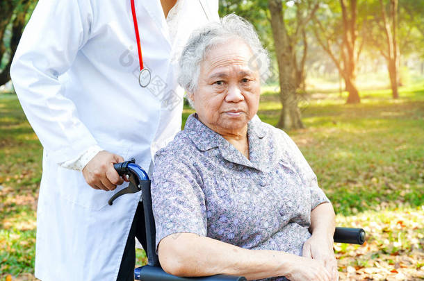 <strong>医生</strong>帮助和护理亚洲<strong>老年</strong>或<strong>老年</strong>老太太女病人坐在轮椅在公园在护理医院病房：健康强医疗理念