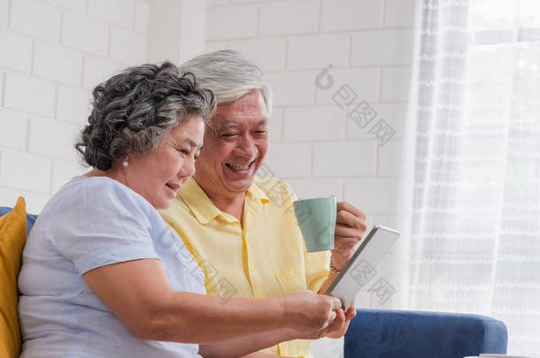 亚洲老年夫妇使用表计算和喝咖啡坐
