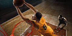 身着运动服的篮球运动员在职业篮球场上带球。扣篮。从箍的高角度视图