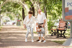 快乐的祖父母和孙女在夏日公园里玩得开心