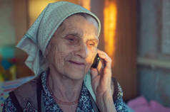 在养老院里戴头巾，用旧电话的老妇人。特写。薄膜颗粒.