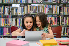两个小快乐可爱的女孩玩平板电脑Pc计算开发