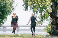 成熟的运动员和女运动员训练与跳绳在公园