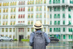 年轻人带着帽子旅行，独奏亚洲旅行家访问雨布