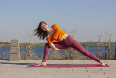 瑜伽练习-妇女做瑜伽姿势冥想在公共公园体育健康概念.