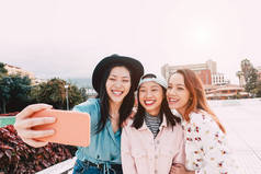 快乐的亚洲女孩采取自拍与移动智能手机户外 - 年轻的时尚青少年有乐趣与新技术应用程序 - 人，社会，媒体，友谊，技术和青年生活方式的人的概念