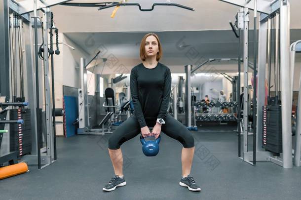 强大的年轻<strong>健身</strong>女子训练与重量级在<strong>健身</strong>房。运动、<strong>健身</strong>、健美、训练、生活方式和人的概念