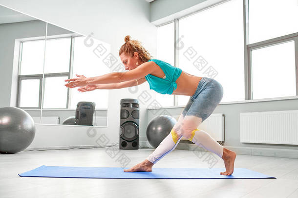 有吸引力的<strong>运动</strong>的女人做<strong>运动</strong>在地板上在现代味觉工作室美丽的<strong>运动女孩</strong>坐着, 伸展她的腿和手臂
