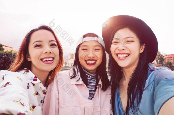 快乐的亚洲女孩自拍与<strong>手机手机</strong>户外-年轻的社交朋友有乐趣在户外<strong>拍摄</strong>自己的照片-人, 千年一代和青年生活方式的概念