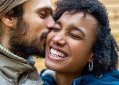 恋爱中的一对夫妇在秋天的公园里散步。非洲裔美国人女孩与欧洲人.