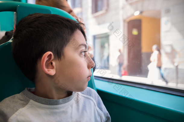 小男孩坐在去学校的巴士椅子
