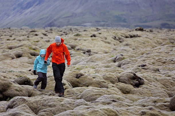 两个家庭, 父亲和儿子, 一起探索冰岛的苔藓熔岩田, 积极度假和家庭冒险的概念, 复制空间的权利