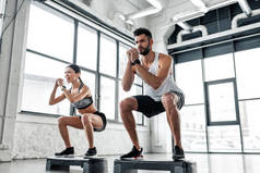 在健身房的继步平台运动服装训练中, 集中运动年轻夫妇的低角度视角 