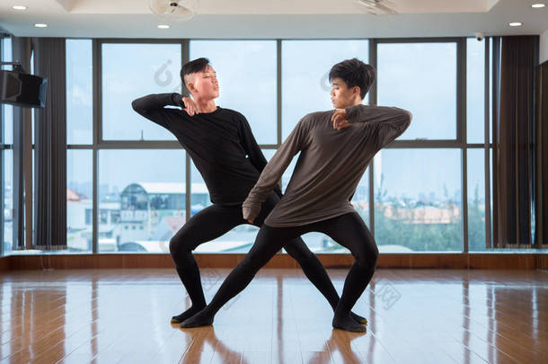 两个英俊的亚洲男人表演当代<strong>舞蹈</strong>动作附近的巨大窗口在时尚的<strong>工作室</strong>在一起