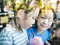 快乐的亚洲孩子享受他们的饮料在咖啡店, 生活方式的概念.