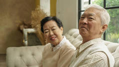 富有的亚洲老年夫妇幸福地拥抱在豪宅里