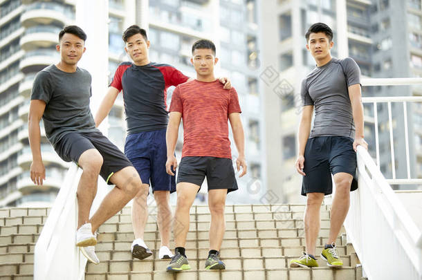 一个由四名亚洲年轻运动员组成的团队站在<strong>台阶上</strong>的户外肖像
